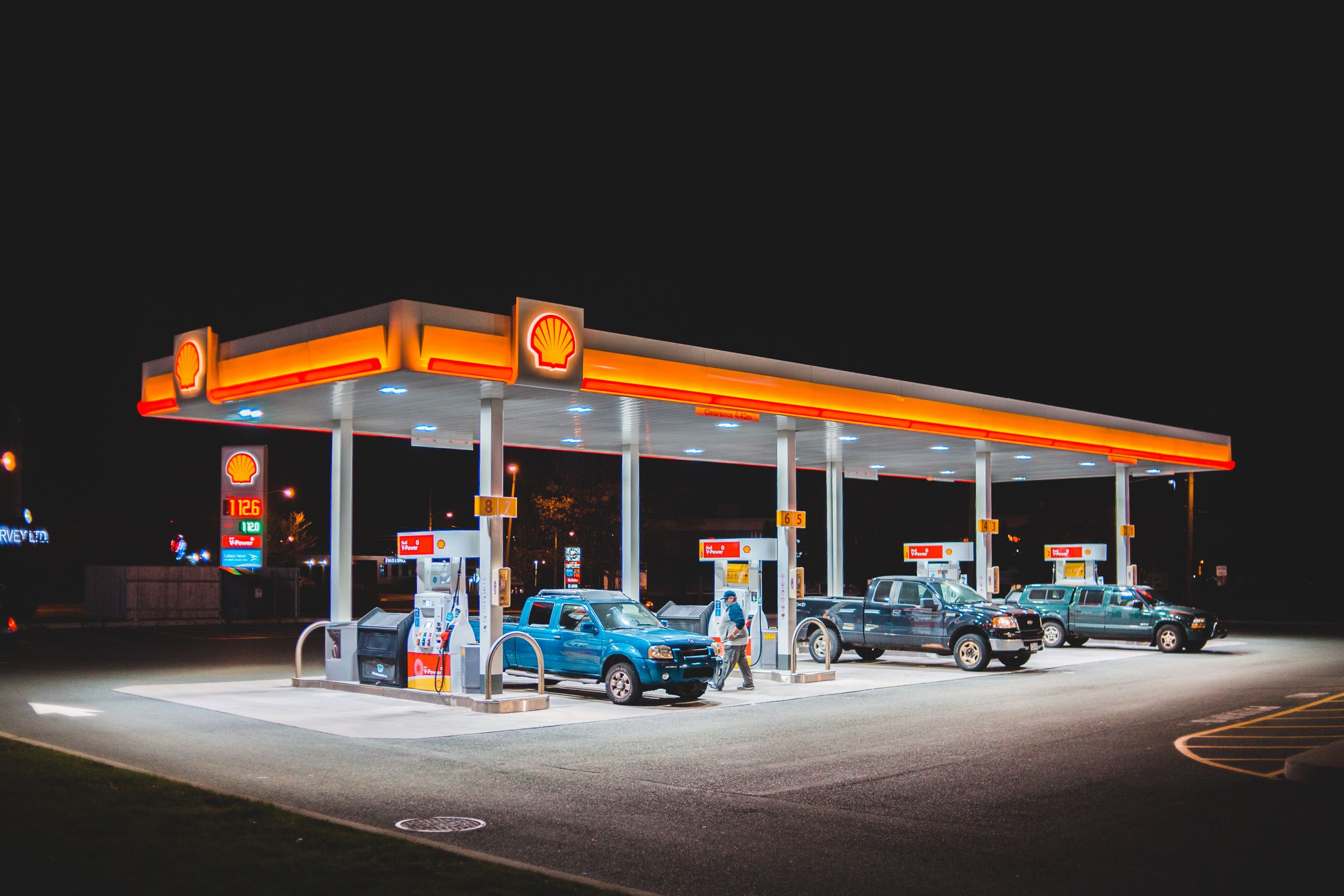 Fuel station canopy with vehicles being refuelled at night